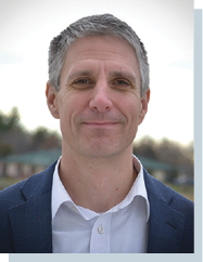 A man wearing a blue suit and white shirt is smiling. AI generated content